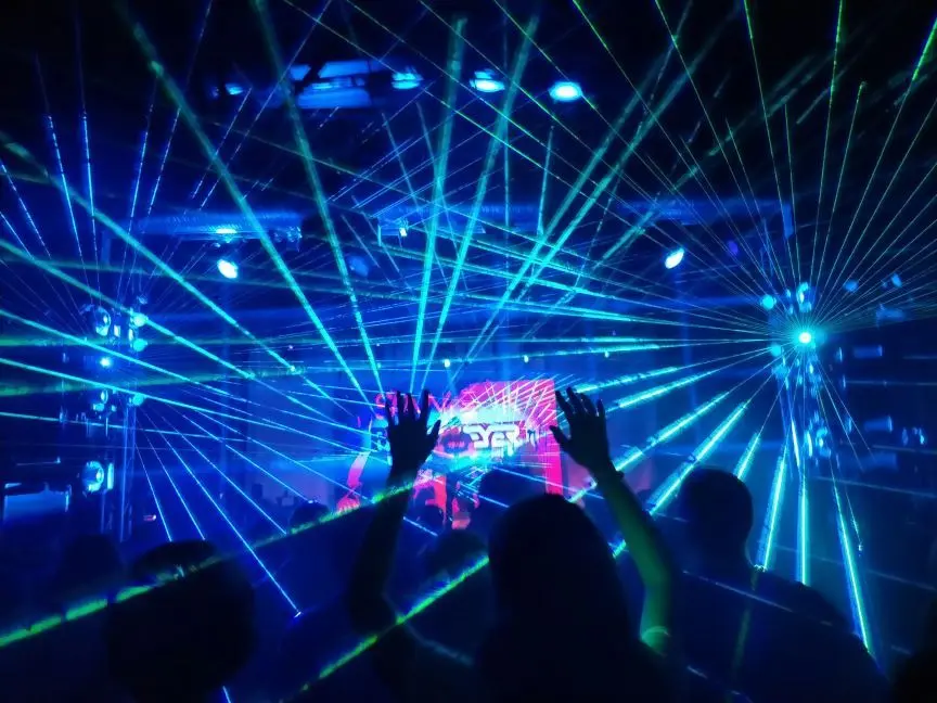Público disfrutando de una sesión de DJ con espectáculo de luces láser