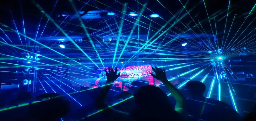 Público disfrutando de una sesión de DJ con espectáculo de luces láser