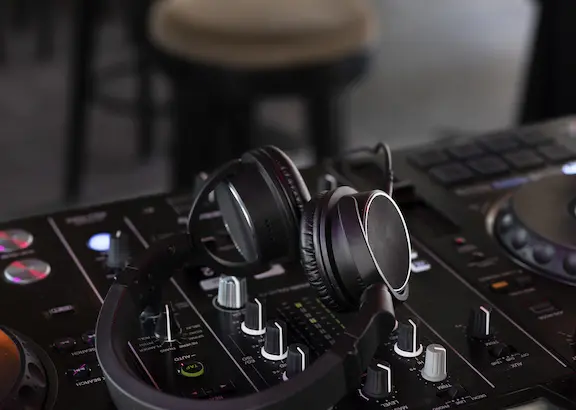 Auriculares de DJ sobre una mesa de mezclas en un entorno de bar o local elegante